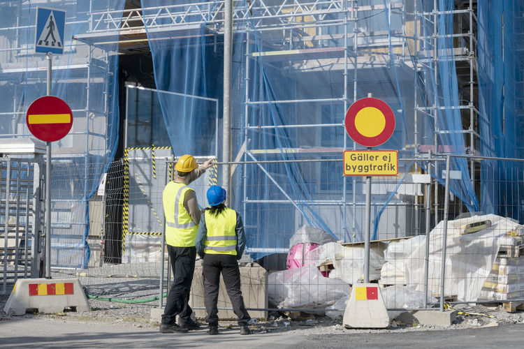Rear view of men working at construction site