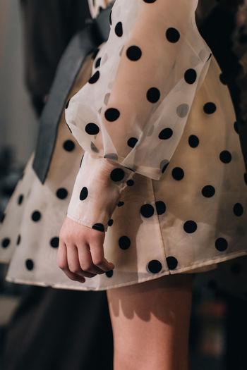 Details of a children's puffy dress with black polka dots