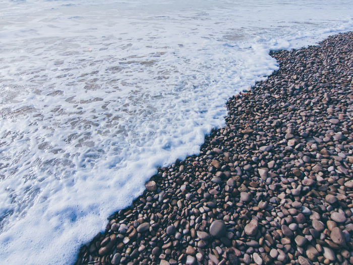 View of surf and pebbles at beach