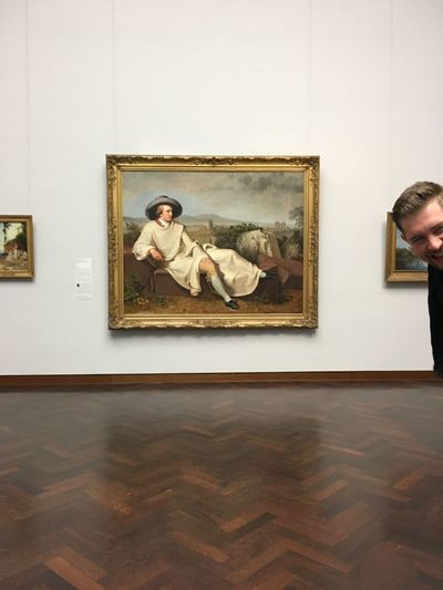 Young man with dog standing in museum