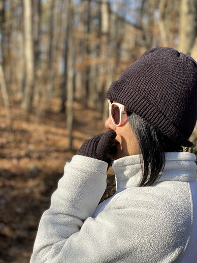 Close-up of woman wearing warm clothing in forest