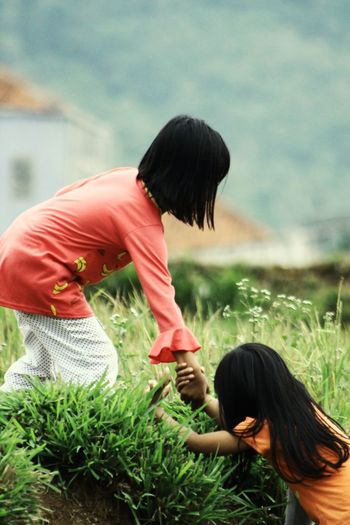 Girl assisting friend on land