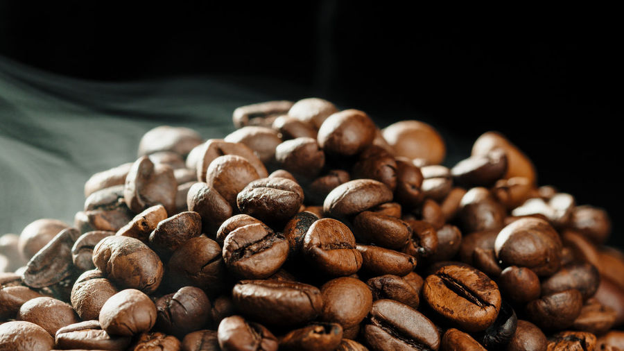 Close-up of roasted coffee beans on black background
