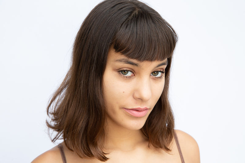 Close-up portrait of beautiful young woman over white background