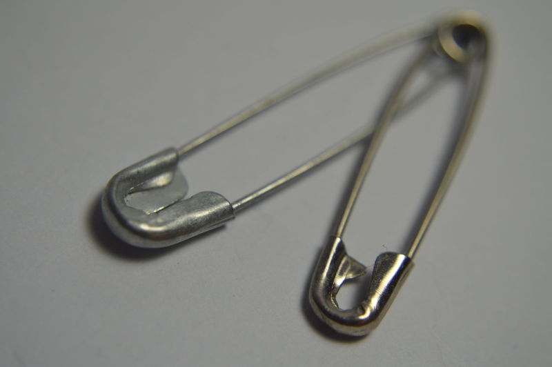 Close-up of safety pin on gray background