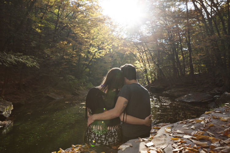 Young couple sitting near a stream