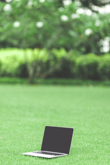 Close-up of laptop on field