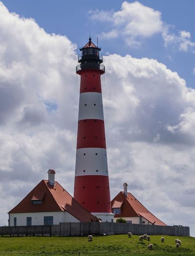 Lighthouse amidst buildings against sky