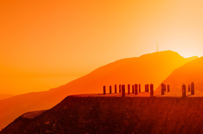 Scenic view of mountains against orange sky