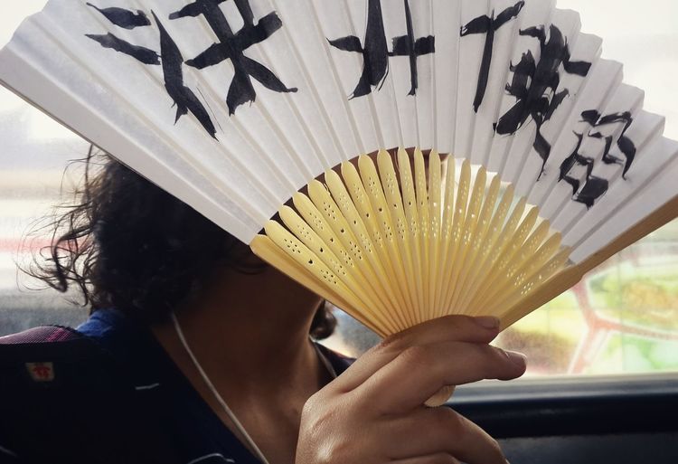 Close-up of woman holding folding fan