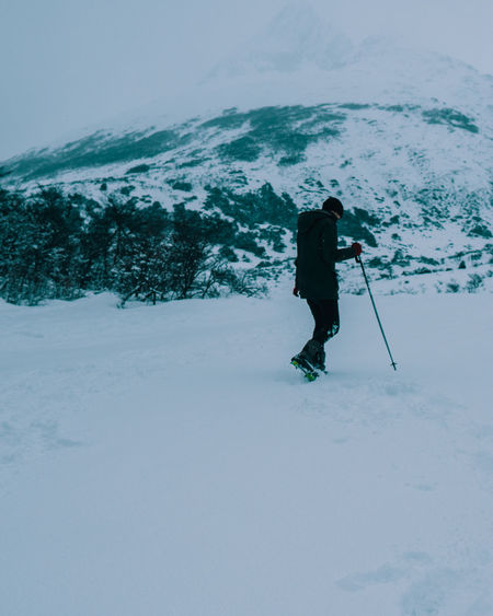 Man walking on snow covered land
