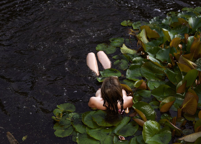 High angle view of naked woman relaxing in lake