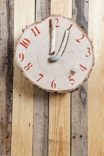 Close-up of clock hanging on wooden wall