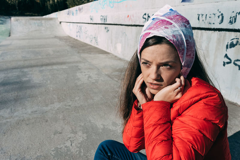 Close-up of young woman sitting at skateboard park