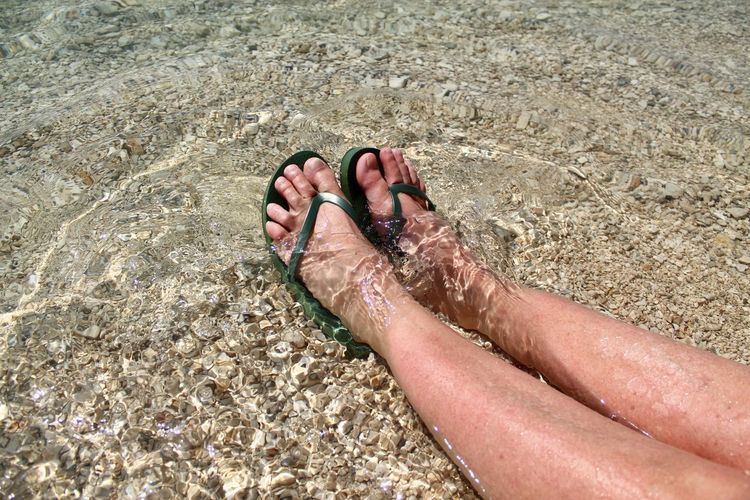Low section of person relaxing on beach