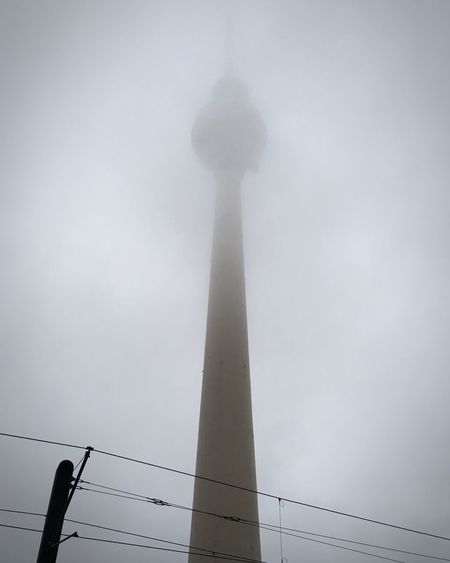 Low angle view of communications tower in city