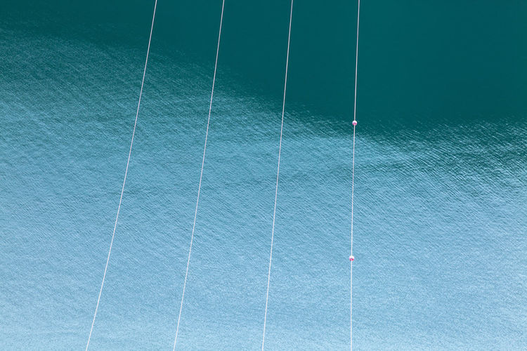 High angle view of power lines against sea water