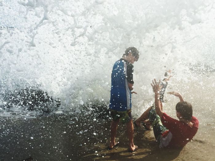 Boys enjoying on shore during high tide