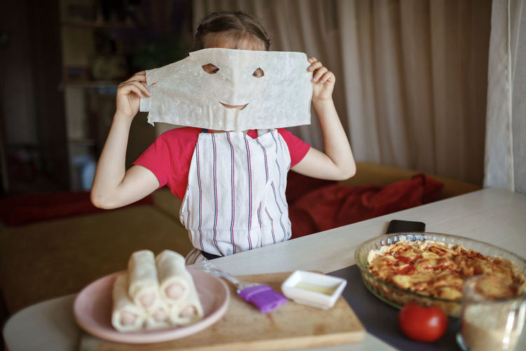Girl covering face with wax paper