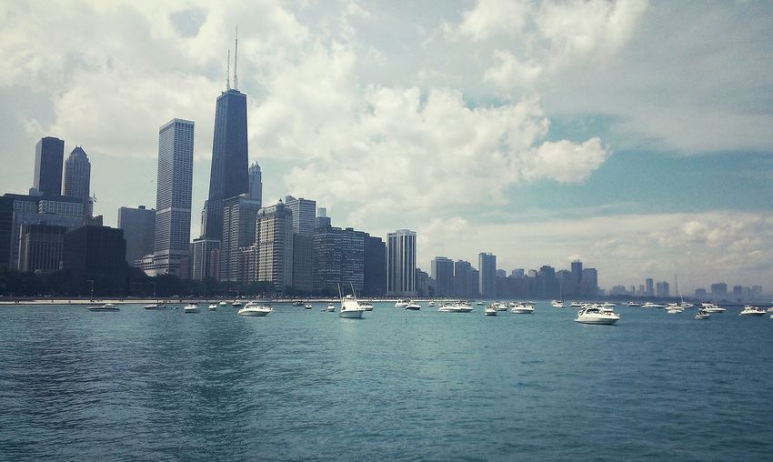 Boats sailing in lake michigan with cityscape in background