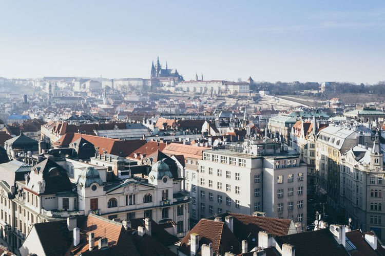 Cityscape of prague on a sunny and cold winter day with blue sky, castle in the background