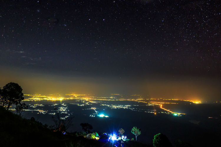 Illuminated city against sky at night