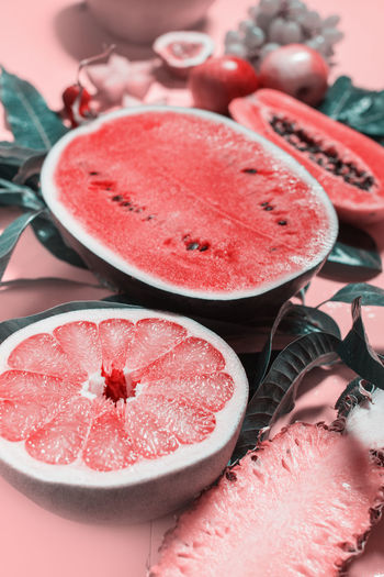 Water melon, grapefruit, pine apple, papaya fruit exotic cut in half. tropical fruits on pink