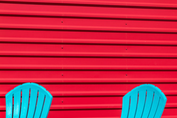 Blue chairs in front of red wall