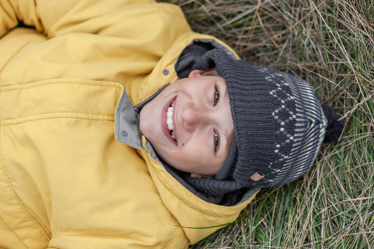 Portrait of smiling boy lying on field