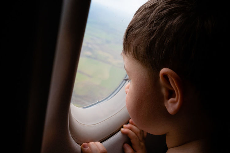 Portrait of boy in airplane window