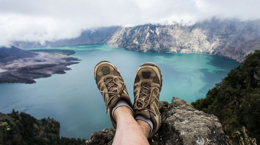 Low section of hiker on rock with river in background