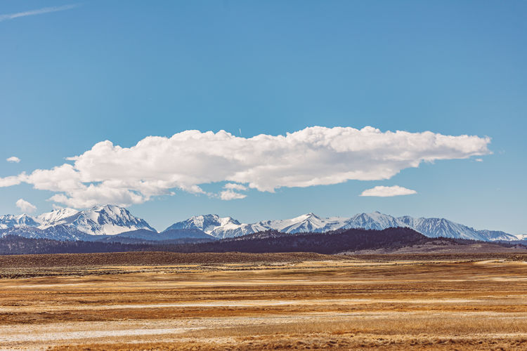 Scenic view of snowcapped mountains against blue sky