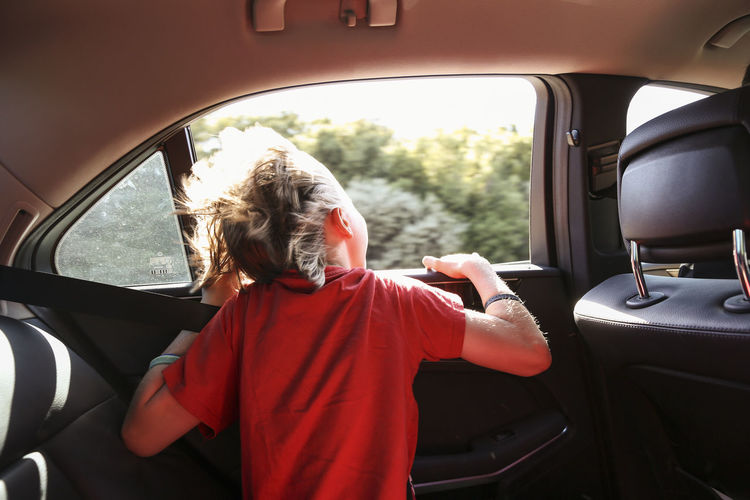 Boy looking through car window