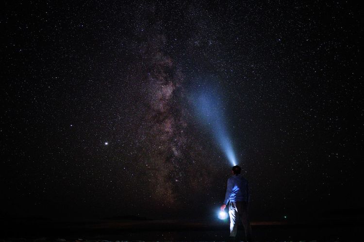Full length of man standing against star field at night