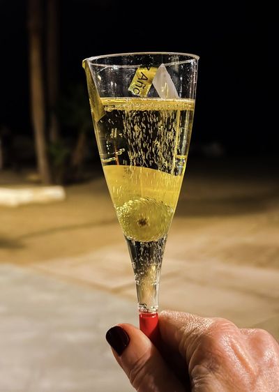 Holding a glass of cava with grape on new years eve