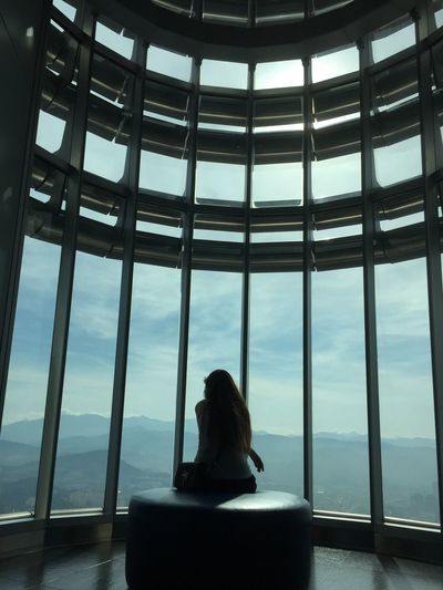 Rear view of woman sitting in petronas tower