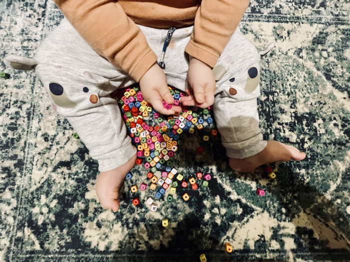 Low section of baby girl with toy toys