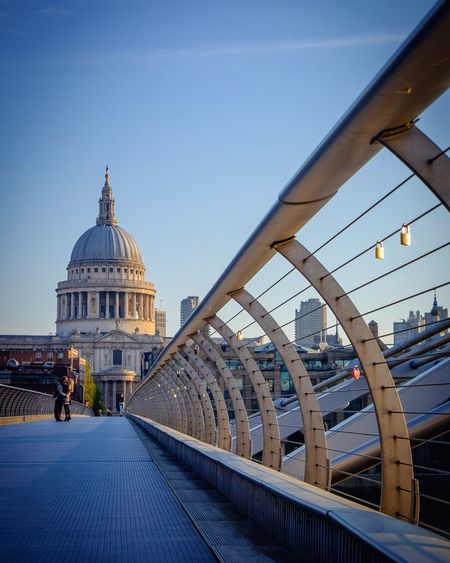 Couple kissing on london millennium footbridge against st paul cathedral in city