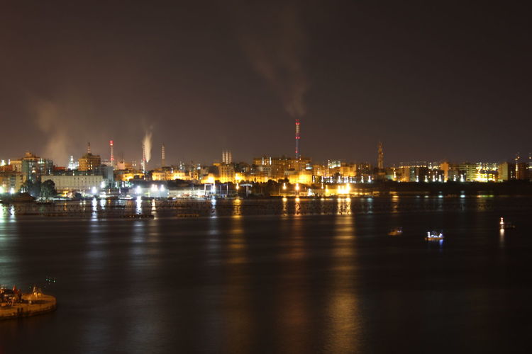 River with illuminated structures in distance