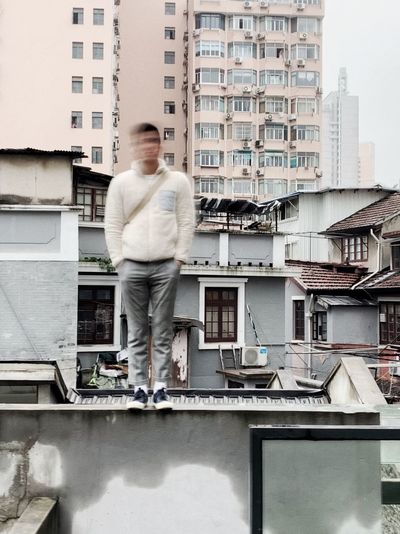 Full length of man standing against buildings in city