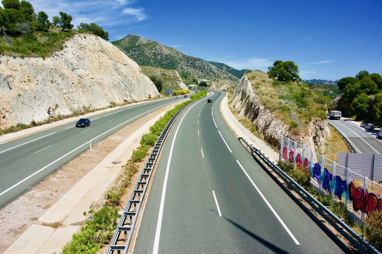 Panoramic view of road leading towards mountain against sky