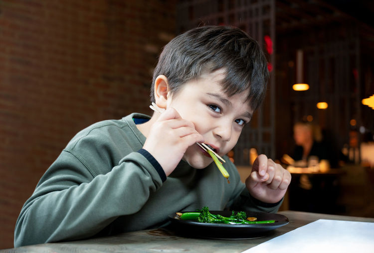 Portrait of boy eating food on table