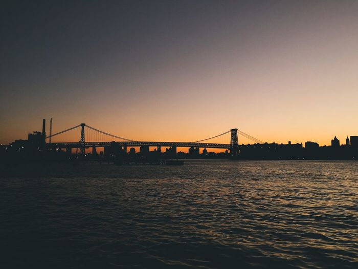 Bridge over river at sunset
