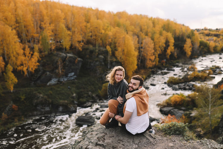 Happy people in love are travel hike in nature in the autumn forest. romantic trip to countryside