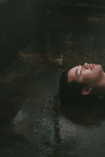 Portrait of young woman lying down in water