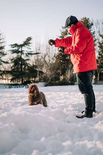 Full length of dog on snow covered field