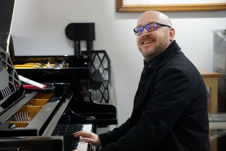 Portrait of smiling man playing piano at home
