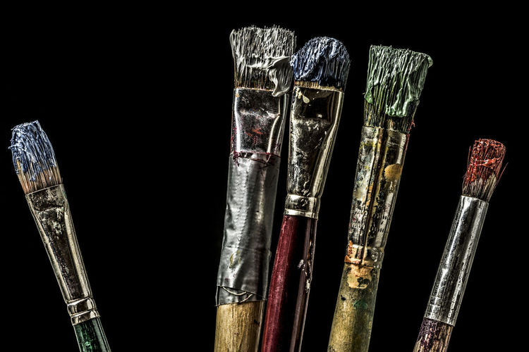 Close-up of paintbrushes against black background