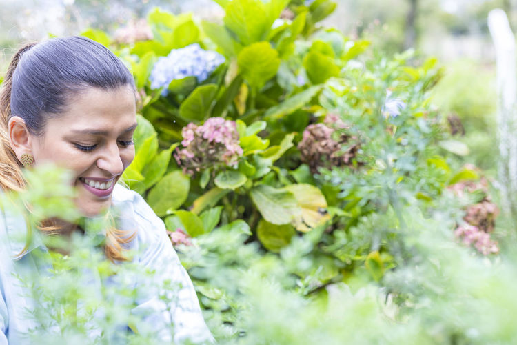 Close-up of smiling woman with flower plants
