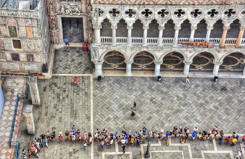 High angle view of people walking by historic building
